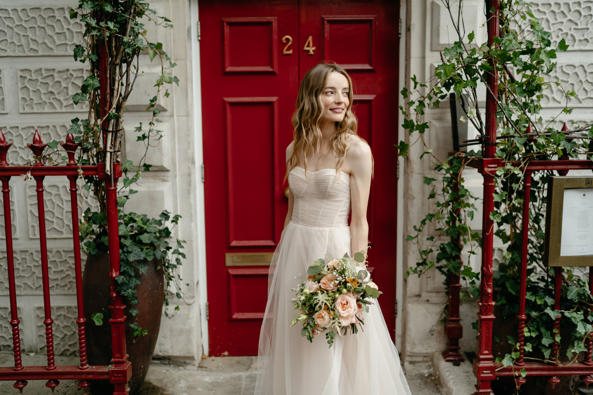 stylish bridal portrait in front of red door in London at Session Arts Club